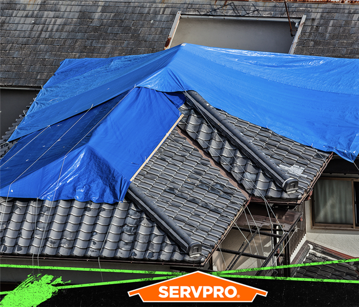 Blue tarp covering the roof of a home.